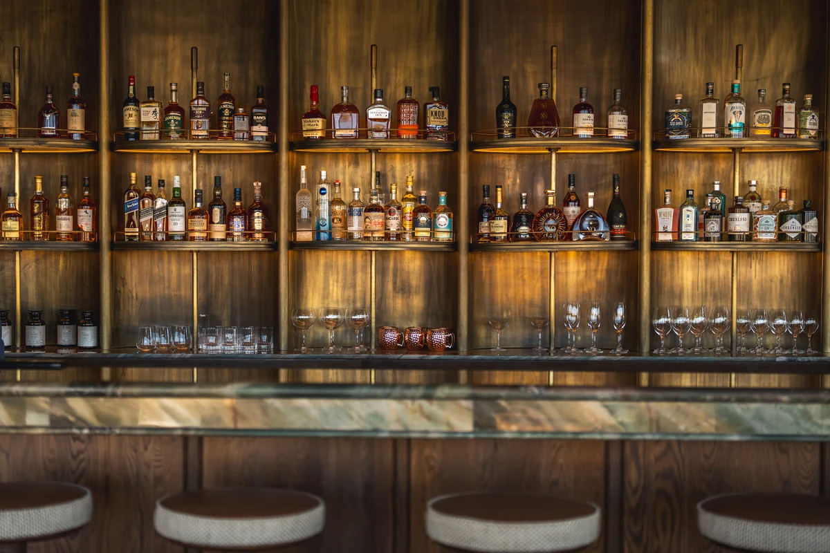 The back bar, its brass shelves lit from within