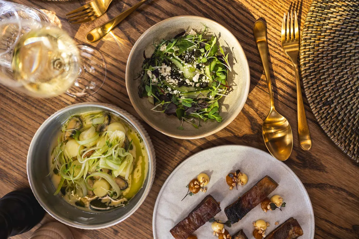Seasonal plates and wine on a timber table